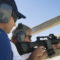 Instructor with man aiming machine gun at firing range